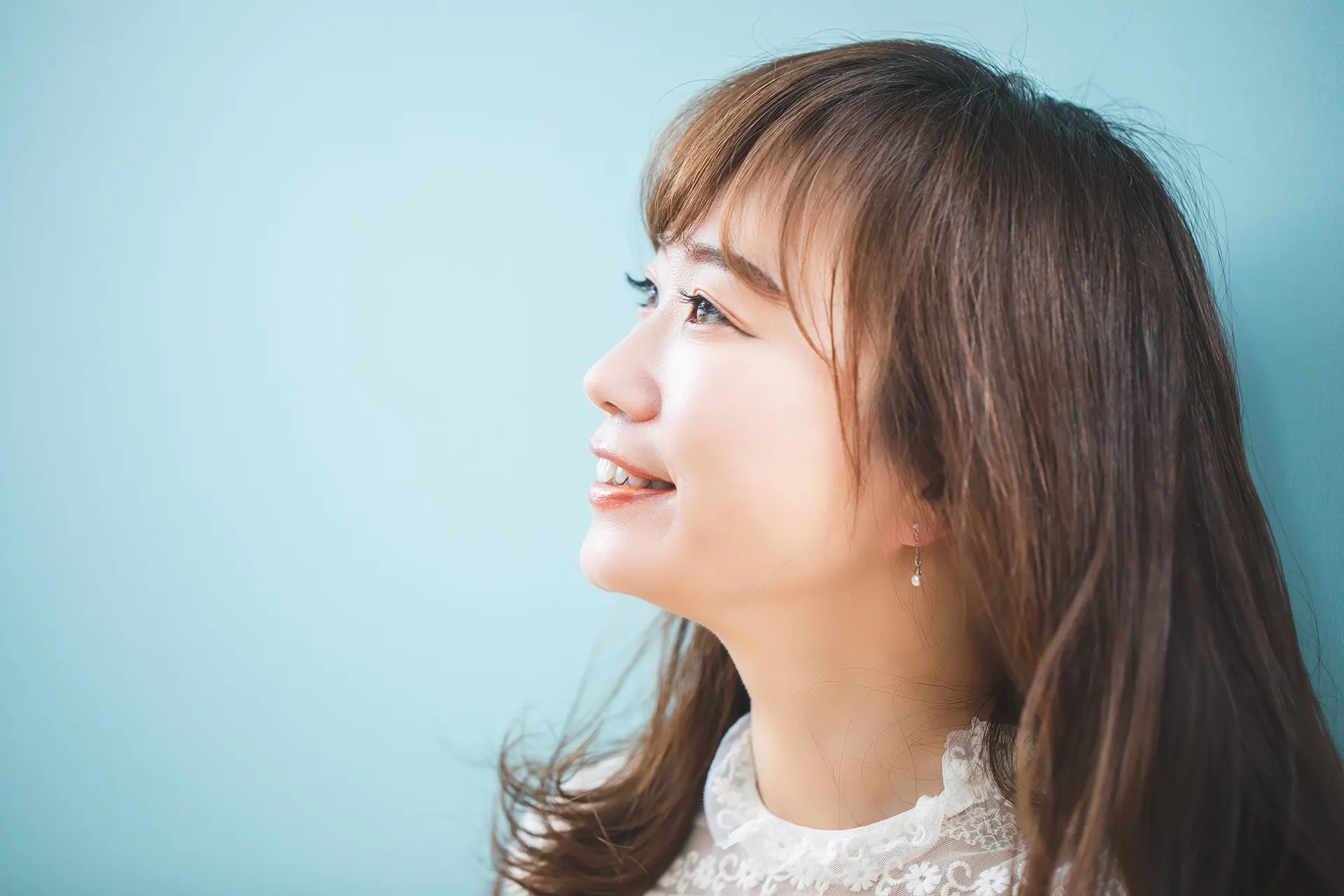 鏡の前で頬の肌を気にする女性のイメージ