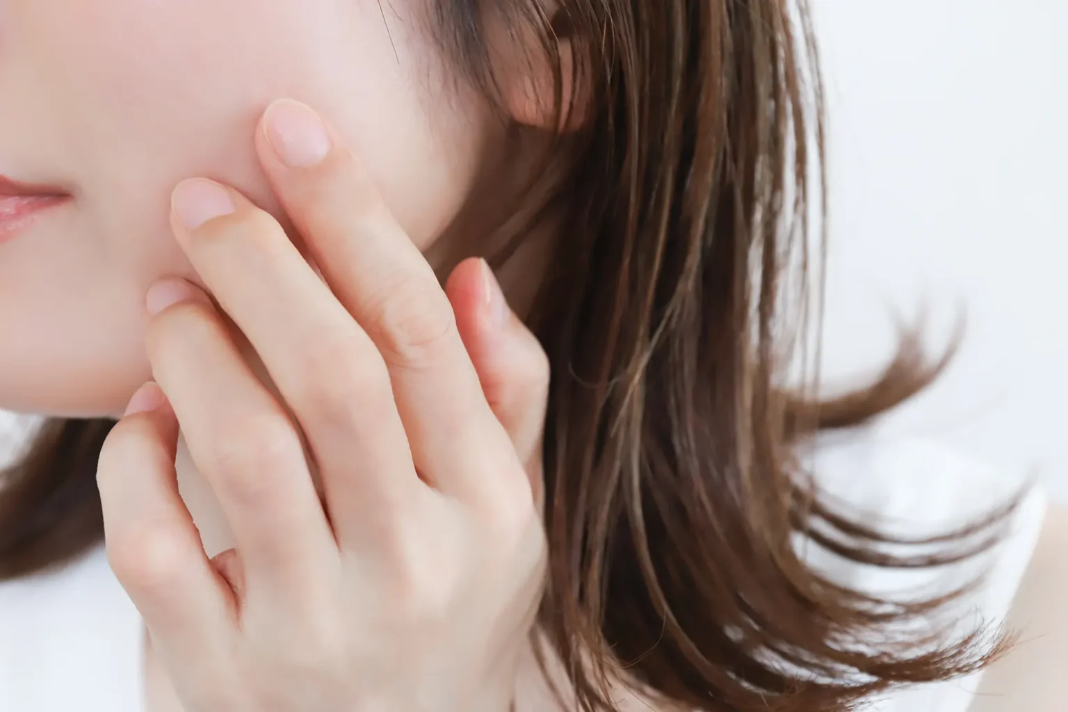 頬に手を添える女性のスキンケアイメージ